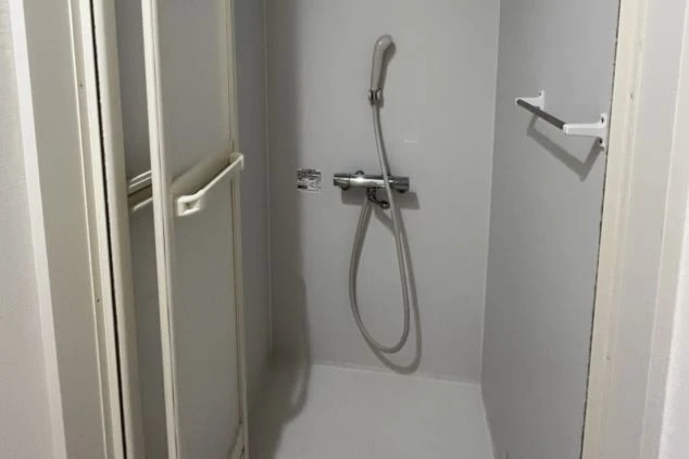 リゾートバイトの寮のシャワールーム。浴槽はなくシャワーのみのタイプで、清潔感のある浴室。