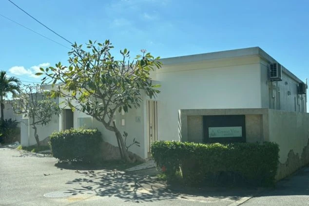 南国リゾートバイトの勤務先の写真。青空に映える白い建物と、プルメリアの木。おしゃれなヴィラで働く住み込み求人。