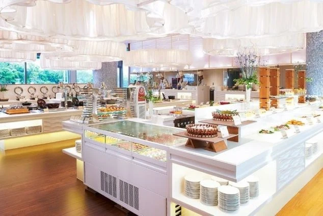 明るく広々としたバイキングレストランの画像。料理やデザートが豊富に並んでいる。