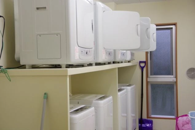 リゾートバイトの個室寮の共用洗濯機・乾燥機の画像。