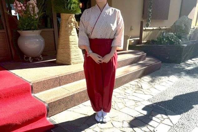 赤い袴風のパンツと小紋柄の上着を合わせた、旅館の女性仲居用制服