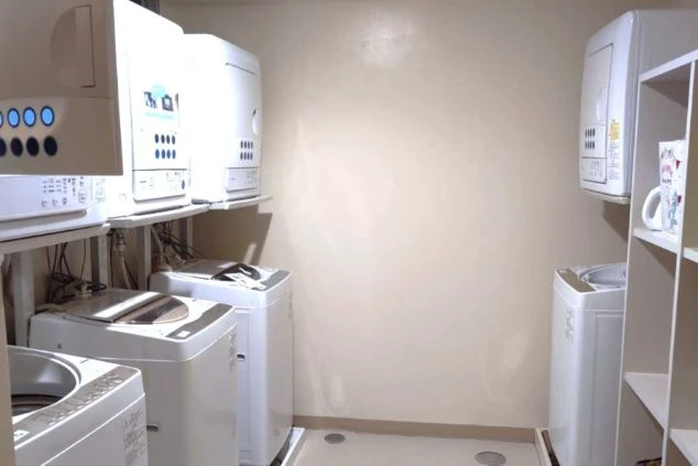 寮の共同ランドリースペース。洗濯機と乾燥機が複数設置されており、入寮者が自由に利用できる。