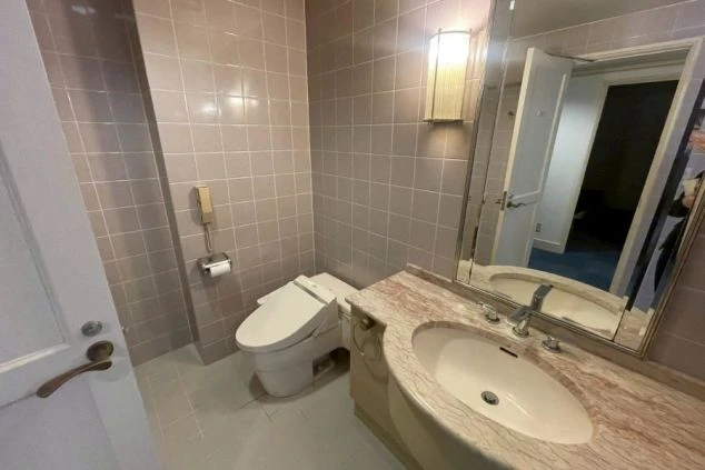 リゾートバイト寮の豪華な洗面所。大理石調の洗面台と大きな鏡、ウォシュレット付きトイレが一体になった、清潔感のある設備。