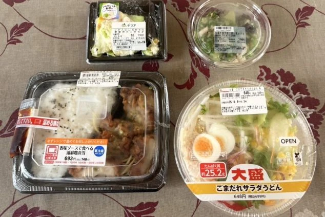 リゾートバイトの賄いの画像。唐揚げ弁当、ごまだれサラダうどん、カット野菜など。