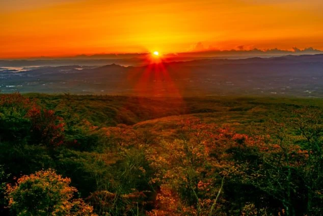 那須高原から見た朝日の画像。山の稜線から太陽が顔を出し、空全体がオレンジ色に染まっている。リゾートバイトの寮から見える景色や、休日に楽しめる雄大な自然を表す。