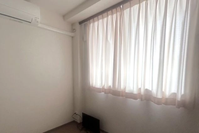 リゾートバイトの個室寮の部屋の画像。窓にはしっかりと日差しを遮るカーテンが備え付けられている。