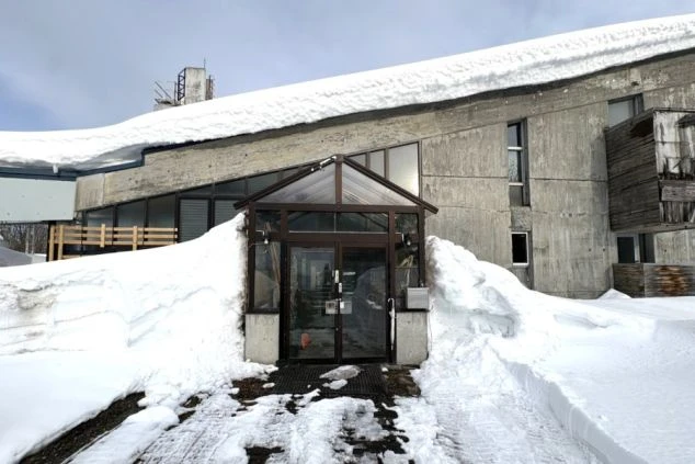 リゾートバイト住み込み求人の寮外観。スキー場近くの雪景色に囲まれた個室寮。