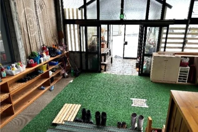 リゾートバイト寮の広い玄関。雪靴を置ける収納棚があり、人工芝が敷かれた清潔感のある住み込み環境。