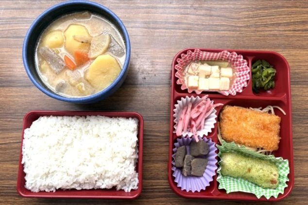 リゾートバイトで提供される、温かい豚汁とボリューム満点の賄い弁当の画像。