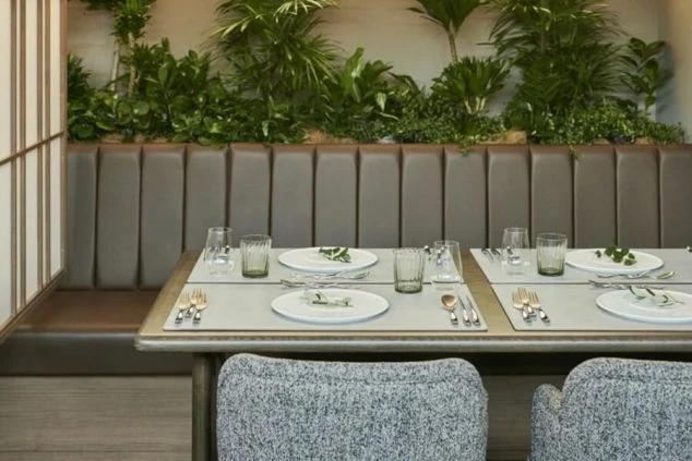 おしゃれなレストランのダイニングの画像。ブラウンのレザーソファとグレーの椅子、そしてテーブルには食器やグラスが並んでいる。リゾートバイトの仕事内容を表す、ホテルのダイニングの画像。