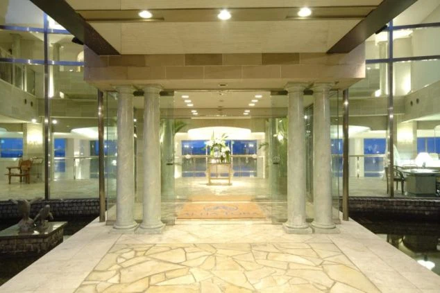 大理石の床や柱、ガラス張りの壁が特徴的なホテルのロビーの画像。高級感あふれる空間が広がり、リゾートバイトの勤務地となるホテルの施設を表す。