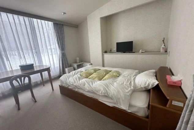 寮の個室。広々ベッド、机、テレビを完備。