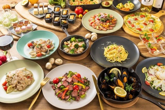 リゾートバイトの仕事風景を表現するイメージ画像。ホテルやレストランで提供される、肉料理やパスタ、魚料理などが並んだ豪華な洋食。