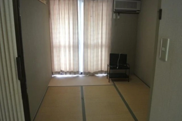 リゾートバイトの個室寮の和室。畳敷きの部屋にテーブル、テレビ、エアコンが備え付けられている。落ち着いた環境で生活できることを伝える画像。