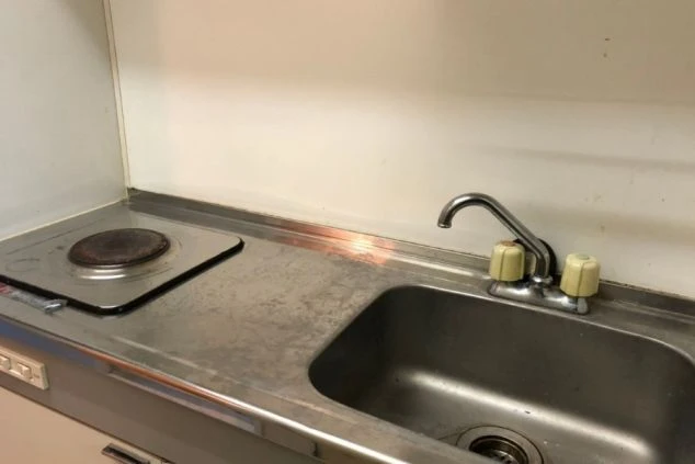 リゾートバイトの個室寮にあるキッチン。コンロとシンクがコンパクトにまとまっており、簡単な調理が可能。自炊を考えている求職者向け。
