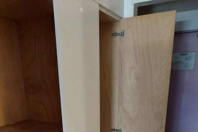 ワクトリの社員が出張で撮影した、リゾートバイトの寮に備え付けられた収納棚の画像。木目調の扉を開くと、衣類や荷物を収納できるスペースが広がる。長期滞在でも安心の収納設備を示す。