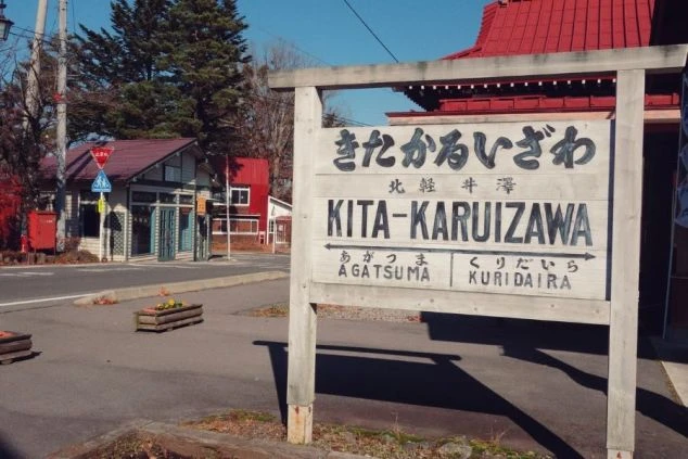 群馬県吾妻郡にある「北軽井沢駅」の看板。レトロな雰囲気の駅舎が写っており、自然豊かな観光地でのリゾートバイトのイメージを伝える。