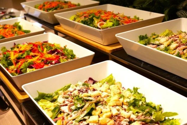 彩り豊かな新鮮な野菜が並ぶ、ホテルのビュッフェレストランのサラダコーナーの画像。