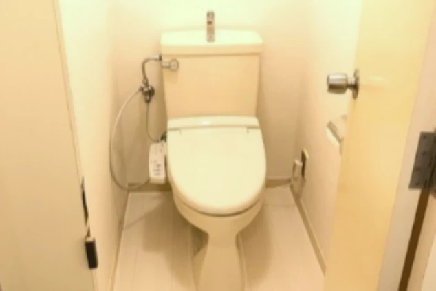 リゾートバイトの寮の個室トイレ。白を基調とした清潔な空間に、温水洗浄便座が設置されている。