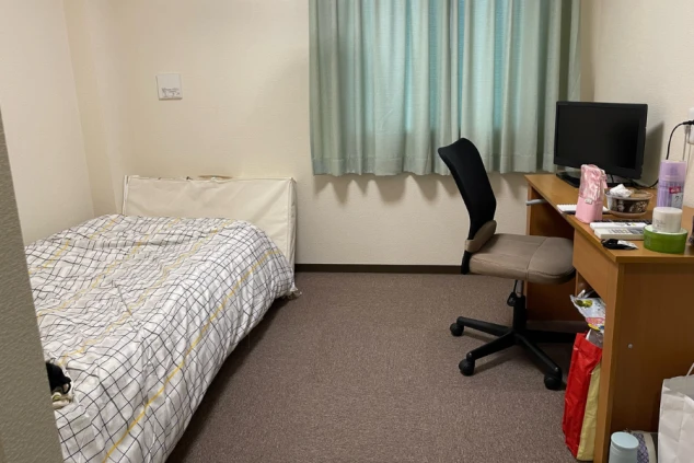 リゾートバイトの個室寮の室内。ベッド、デスク、テレビが備え付けられ、プライベートな空間でくつろげる設備の画像。