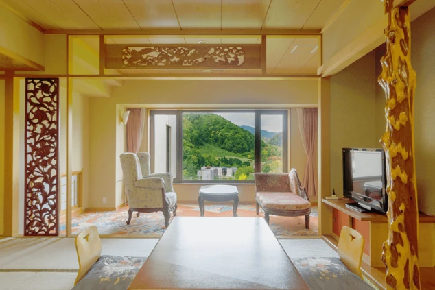  リゾートホテルの客室。和室と洋室が一体になった広々とした空間で、窓からは緑豊かな景色が一望できる。リゾートバイトの寮や仕事場として、快適な環境であることをアピールする画像。