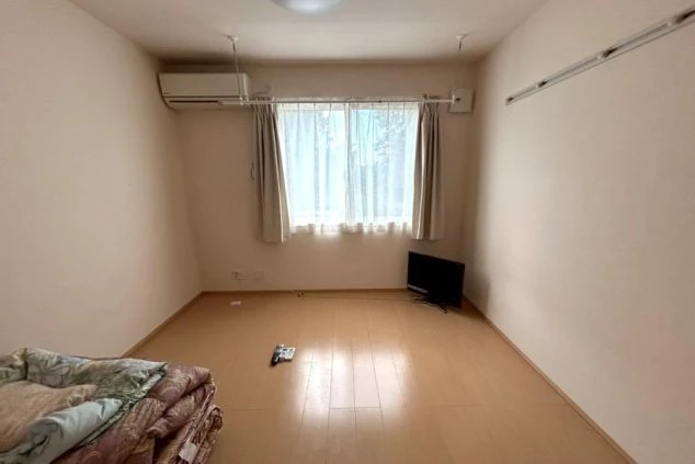 リゾートバイトの寮の部屋の中を撮影した画像。部屋にはテレビが置かれ、床はフローリングで広く使える。リゾートバイトの寮の部屋の画像。