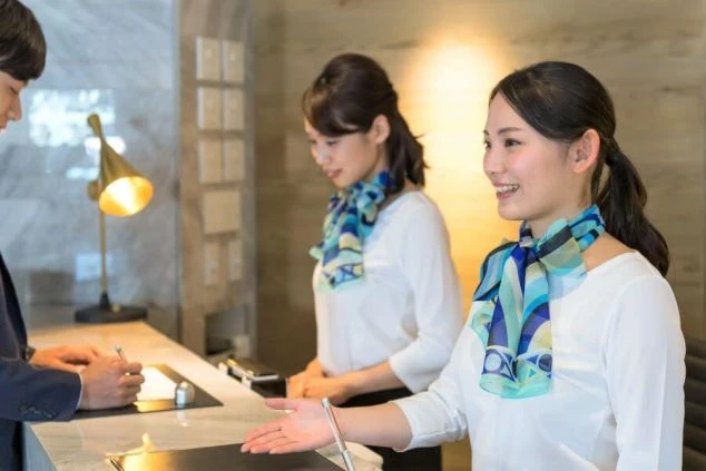 夕日を背景にしたシルエットの男性と、画面上部に「HOKKAIDO 函館 WORK TRIP」、下部に「絶品まかない3食無料」「温泉無料×完全個室寮」の文字が書かれている。