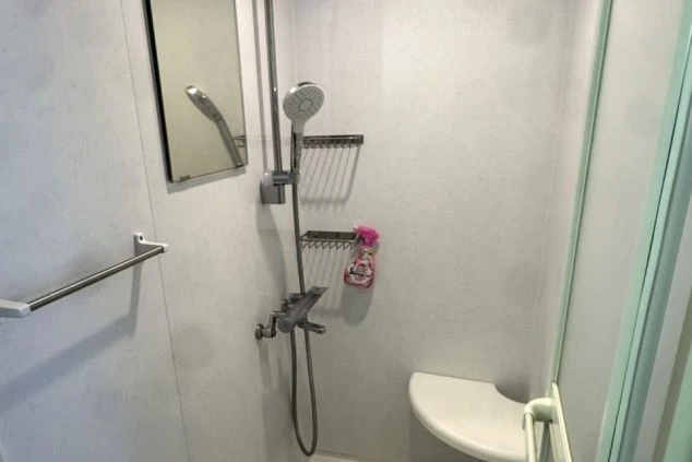 リゾートバイトの個室寮にあるシャワールーム。シャワーと椅子、鏡が備え付けられた、清潔感のある設備の画像。