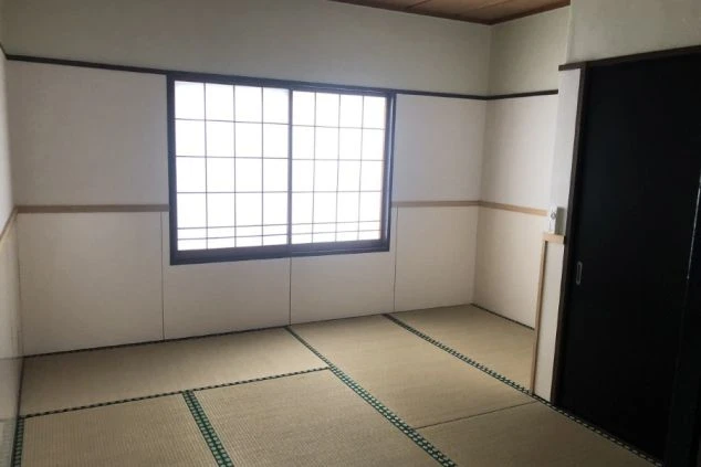 リゾートバイトの個室寮の部屋画像。畳敷きの和室で、障子のある窓と押し入れ(またはクローゼット)の扉が見える、清潔感のある住居スペース。
