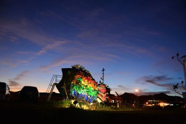 夜空の下、イルミネーションでライトアップされた建物。冬のリゾートバイトの風景。