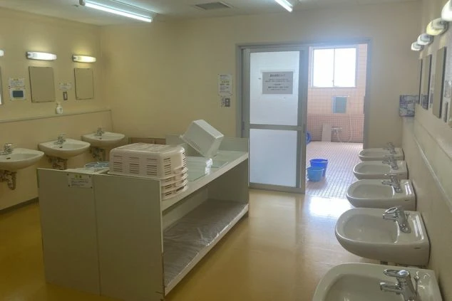 リゾートバイトの寮にある、共同浴場の脱衣所。洗面台が複数並び、広々としているので、混み合う時間でも快適に着替えができます。