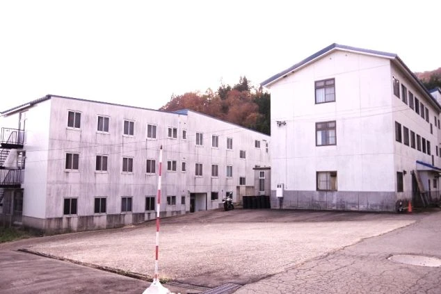 リゾートバイトの寮（従業員宿舎）の外観。シンプルな白い建物で、自然に囲まれた場所にあり、落ち着いた住み込み生活が可能。