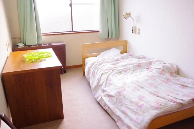 リゾートバイトの寮に完備された個室。ベッドと机、窓から光が差し込む明るい部屋で、快適な一人暮らしが可能。