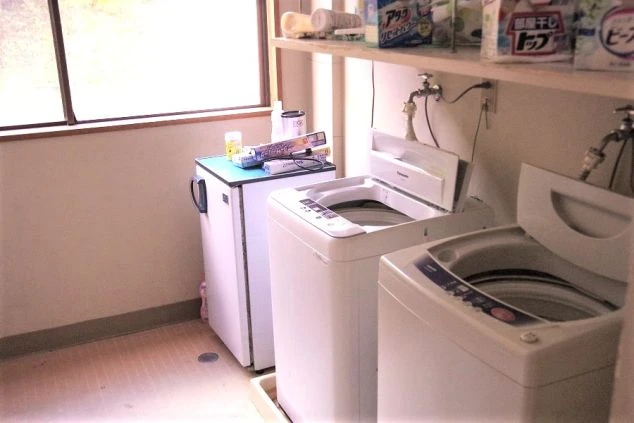 リゾートバイトの寮に完備された、洗濯機と小型冷蔵庫。生活に必要な家電が揃い、自炊や洗濯もできる便利な環境。