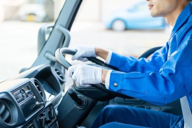 運転席に座る男性がハンドルを握っている画像。運転業務や送迎バスの運転手など、運転が得意な人におすすめの職種。