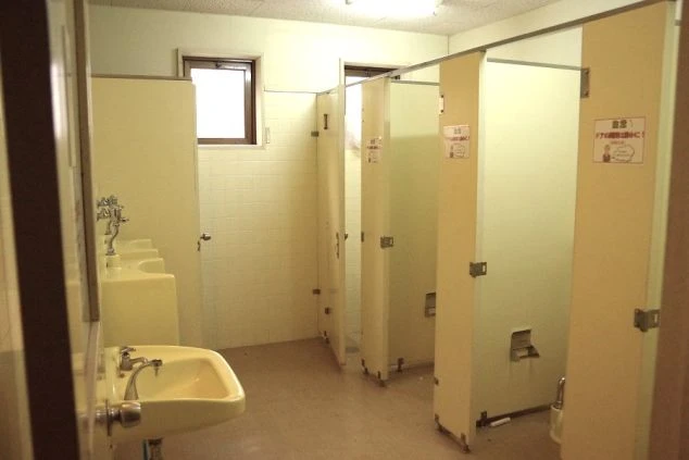 リゾートバイトの寮にある、複数の洗面台と個室トイレが並んだ共同スペース。清潔に保たれており、安心して利用できる。