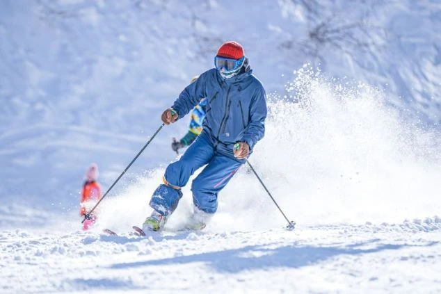 雪景色の中、スキーヤーがダイナミックに滑っている画像。