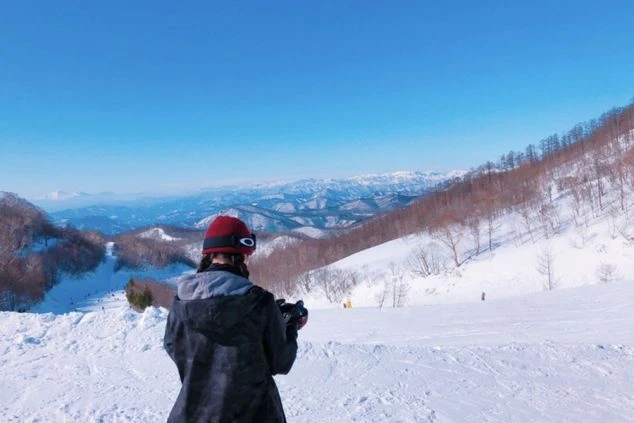 ゲレンデでたたずむ女性の写真。リゾートバイトならリフト券無料で楽しめる。