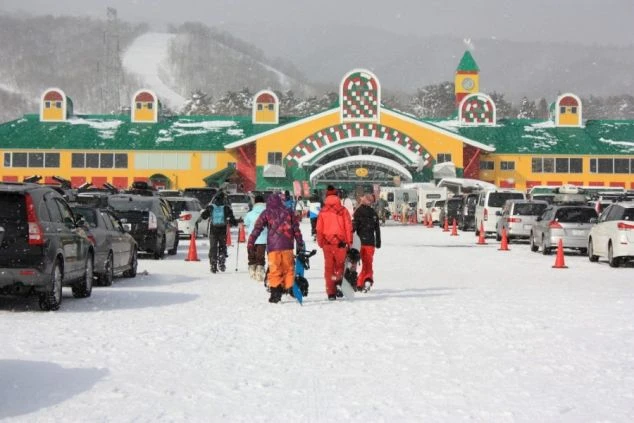 カラフルでユニークなデザインのスキーセンター。雪が降る中、多くのスキーヤーで賑わっています。