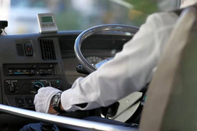 運転席に座る男性がハンドルを握っているイメージ画像。