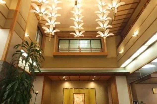 花のような形のライトが天井から複数吊るされた、和風のホテルのロビーの画像。落ち着いた雰囲気のロビーで、リゾートバイトの仕事内容を表す、ホテルのロビーの画像。