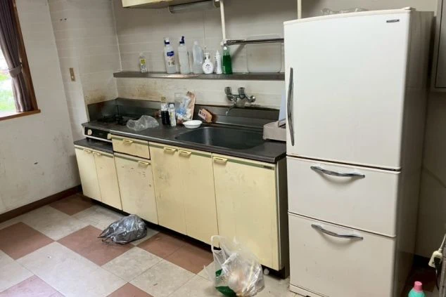 リゾートバイトの寮に備え付けられた、共用キッチンの画像。複数の炊飯器と電子レンジ、そして冷蔵庫が置かれている。リゾートバイトの寮の共用スペースの画像。