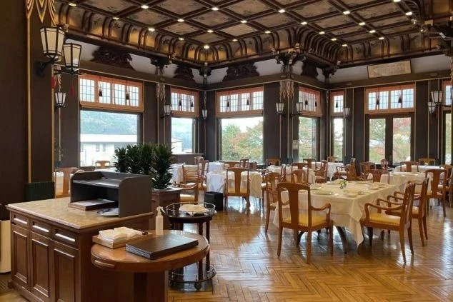 クラシックな雰囲気のホテルのダイニングの画像。たくさんのテーブルが並び、窓からは自然の光が差し込んでいる。リゾートバイトの仕事内容を表す、ホテルのダイニングの画像。