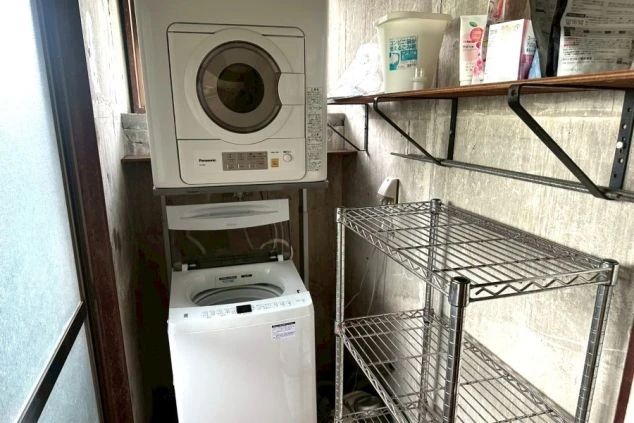 リゾートバイトの寮に設置された、洗濯機と乾燥機。棚も設置されており、洗濯に必要なものを置いておけます。