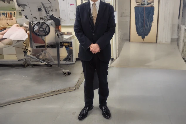 フロントで働く男性。黒いスーツにネクタイを着用した制服で、格式高いホテルの雰囲気を伝える。