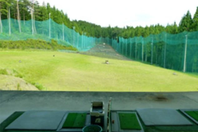 ゴルフ場の練習場。緑の芝生と青い空が広がり、奥には林と大きなネットが見える。リゾートバイトの仕事や、休憩中にゴルフを楽しめることをアピール。
