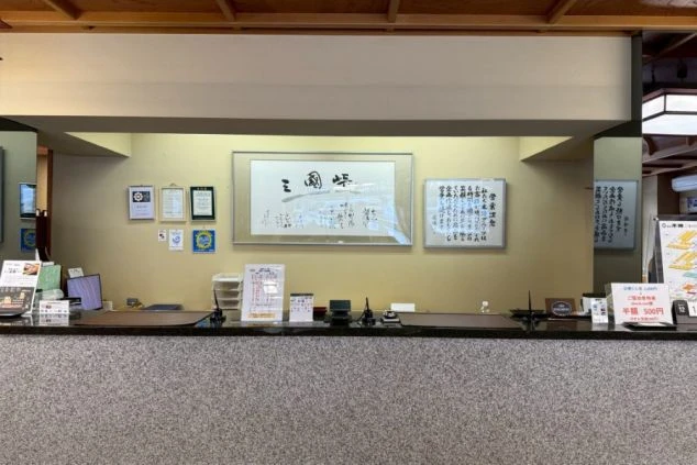 落ち着いた雰囲気の旅館のフロントカウンター。丁寧な接客を学ぶ、リゾートバイトのフロント業務の職場イメージ。