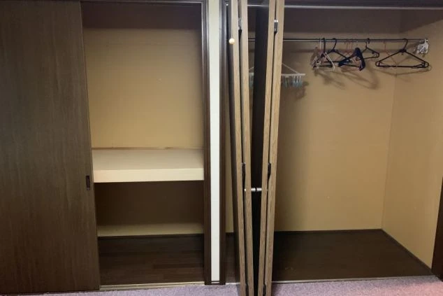 リゾートバイトの寮の、広々とした収納スペースの画像。ハンガーをかける場所と棚があり、荷物を整理して収納できます。