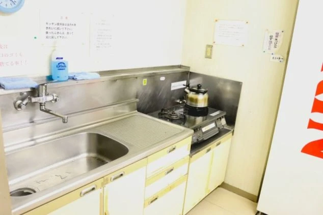 リゾートバイトの寮にある共有キッチンの画像。ガスコンロ、シンク、調理台が揃っており自炊も可能。