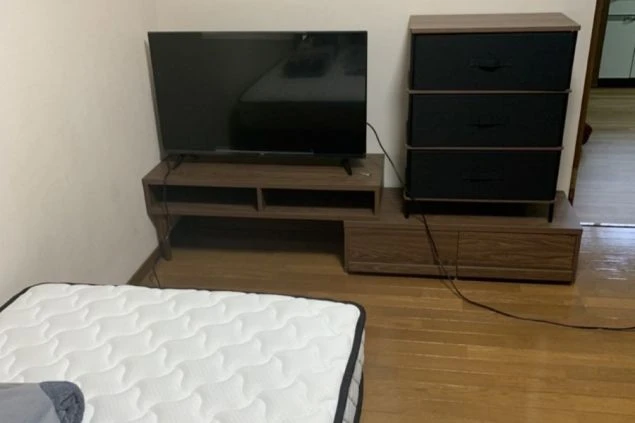 リゾートバイトのシェアタイプ個室寮の部屋の画像。ベッドの奥にTV・棚が見える。